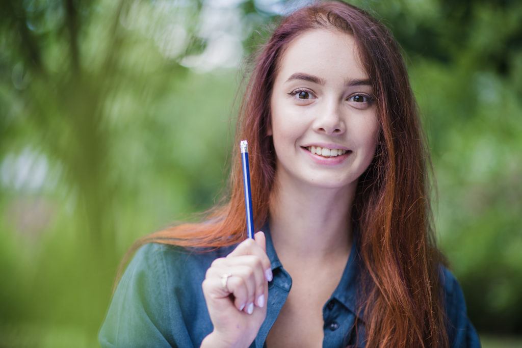 Mujer sonriendo sosteniendo un lápiz